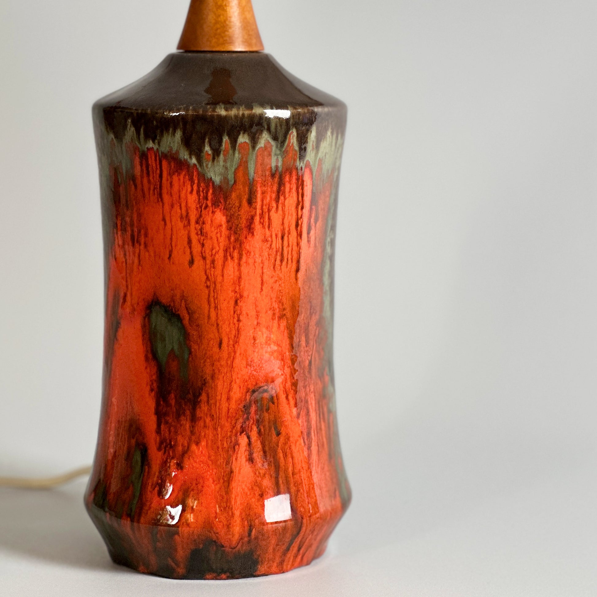 The ceramic table lamp base features bronze-brown tones with vibrant, fiery blood-orange drips at the front, reminiscent of West German pottery with an orange and black drip glaze.