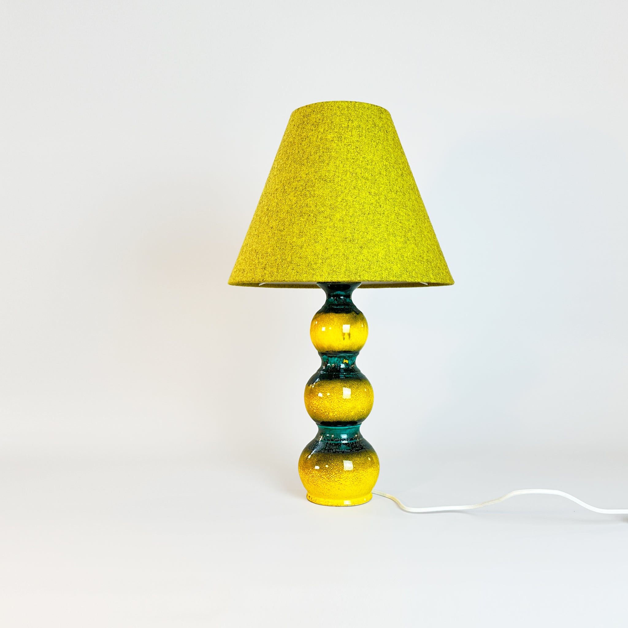 Embrace the joy of simplicity and an uplifting vibe 🌟 This gorgeous, polished, refined lamp base is a unique find, glazed in sunny yellow with mysterious deep ocean green highlights. Paired with a classic empire lampshade, handmade from recycled textured wool in a glowing golden Turmeric hue.